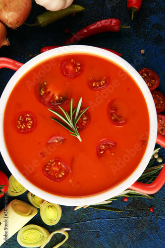 Tomato and fresh rosemary soup with garlic, cracked papper corns, served with cream. Homade tomato soup for dinner