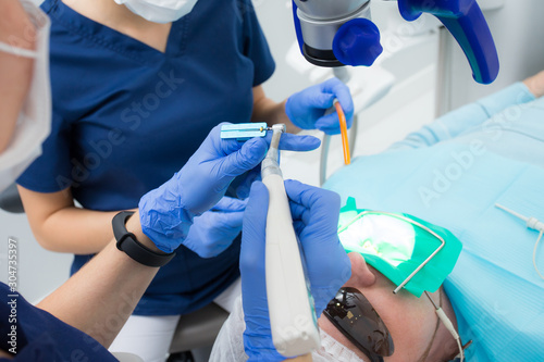 Close-up picture of dental instruments: drill and needle for root canal treatment and pulpitis in hand at the dentist in a blue glove photo