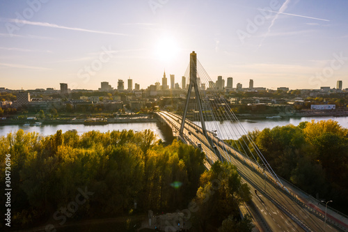 Aerial view of a beautiful cityscape with bridges, a river, and a sports stadium against the backdrop of sunrise. Warsaw, Poland. 