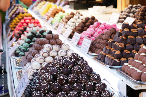 Photography Assortment of delicious chocolate candies for sale on counter of shop, market, cafe