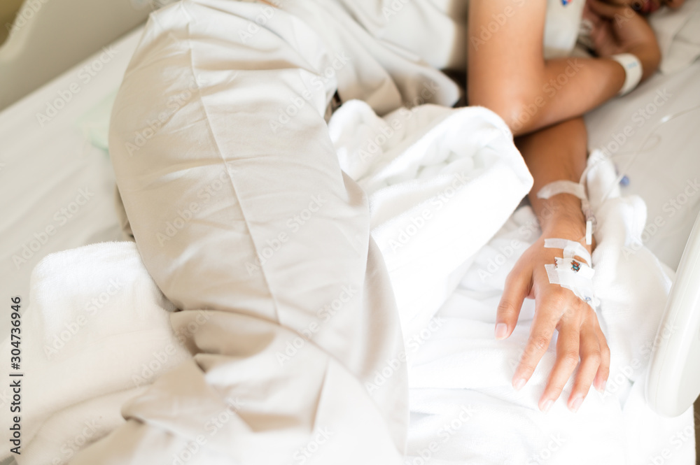 Selective focus young boy hand and set iv fluid intravenous drop saline drip with blurry illness Asian young boy sleeping on hospital bed.Medical treatment concept. Selective focus young boy hand and set iv fluid intravenous drop saline drip with blurry illness Asian young boy sleeping on hospital bed.Medical treatment concept.