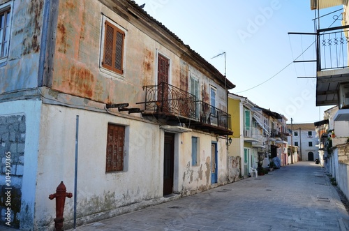 Fototapeta Naklejka Na Ścianę i Meble -  Lefkada, Lefkada Island, Greece. 10/22/2019. narrow streets, old houses, windows, doors, balcony in a European town on the island. cityscape, street without people