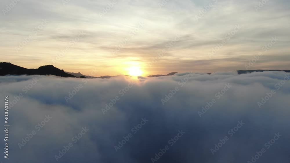 drone flying above the cloud towards the sun among the mountain peaks drone flying above the cloud towards the sun among the mountain peaks