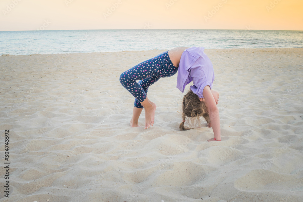 Young gymnast girl perform various gymnastic and yoga exercises