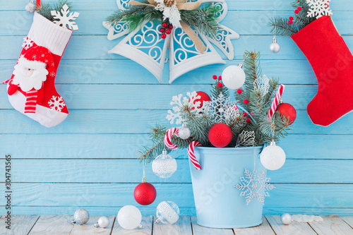 Christmas stocking and fir branches in blue buchet on blue woode photo