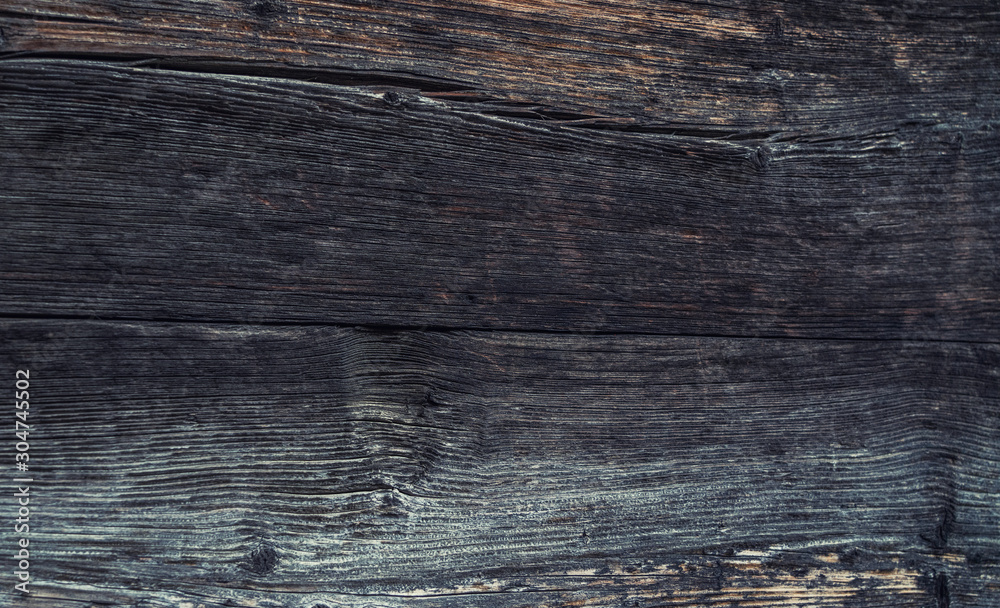 The wall of old wooden house in traditional swiss alpine village. Rural mountain chalet. Dark wood texture background surface with old natural pattern The wall of old wooden house in traditional swiss alpine village. Rural mountain chalet. Dark wood texture background surface with old natural pattern