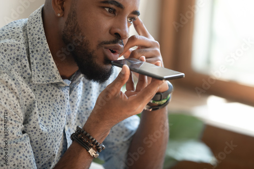 Close up of biracial male using cellphone voice assistant photo