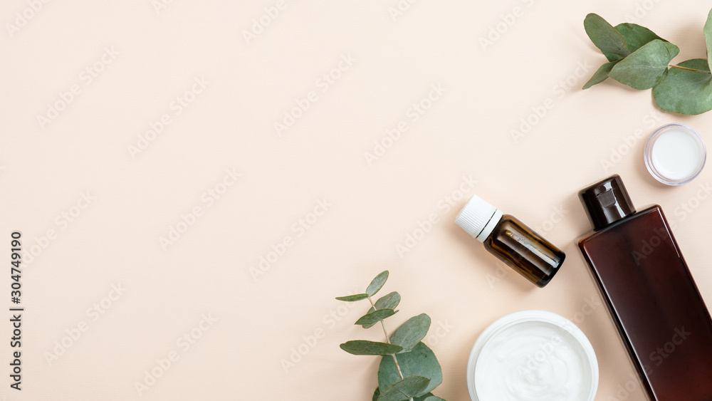 Organic cosmetic products in glass bottle containers and cream jar with eucalyptus leaves on pastel beige background. Bio organic product, zero waste cosmetic concept - obrazy, fototapety, plakaty 