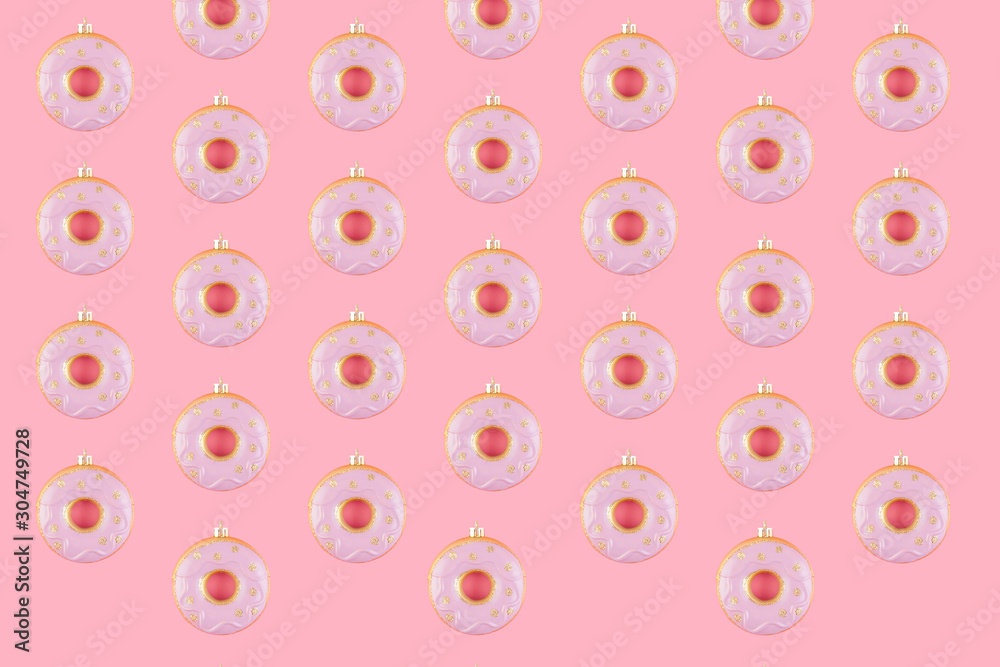 Pattern of New Year donut-shaped Christmas tree toys on a pink pastel background