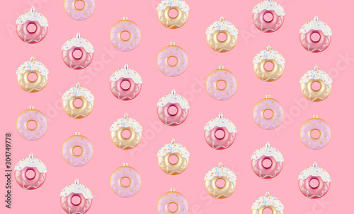 Pattern of New Year donut-shaped Christmas tree toys on a pink pastel background