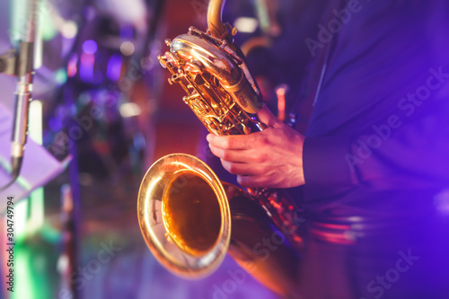 Wall Mural Concert view of a saxophone player with vocalist and musical jazz band in the ba