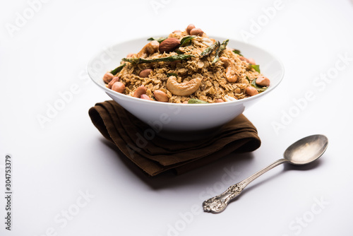 Oats Chivda / Chiwda is a healthy indian recipe with added chilli, peanuts, cashew, almond and curry leaf for flavour. Selective focus photo