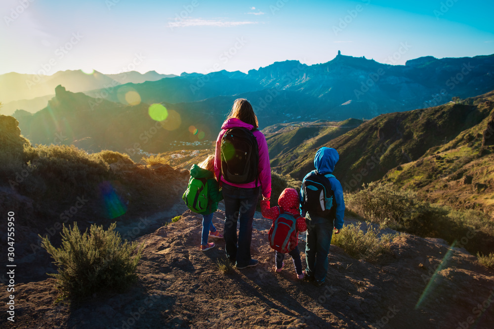 happy family -mother with kids- travel in sunset mountains