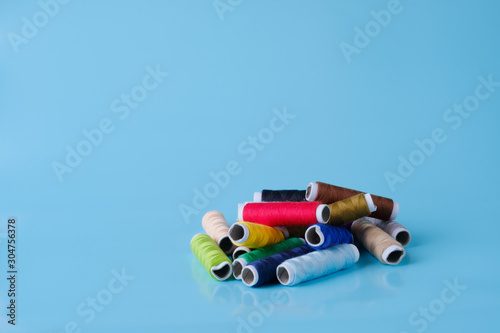 Thread tube colorful on blue background top view and copy space