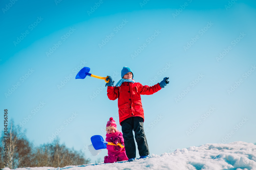 happy kids- boy and girl- play with snow in winter nature