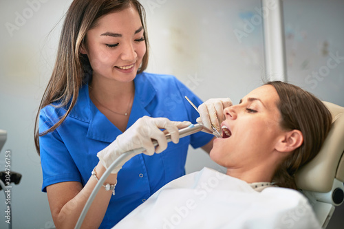 Young woman during the dental procedure with dentist