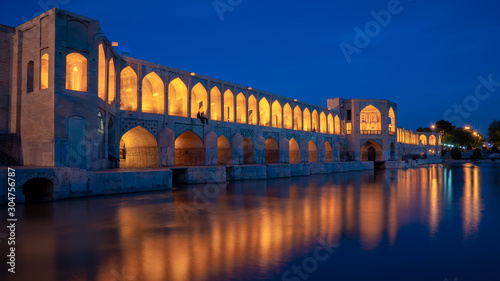 Khaju bridge over Zayandeh river at dusk with lights during blue hour, Isfahan, Iran photo