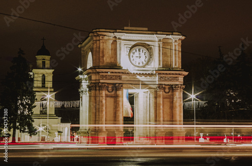 Night long exposure trolleybus light in front of the Triumphal Arch in Chisinau photo