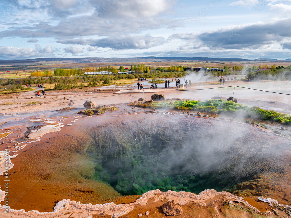 Blue pool with vapour in Haukadalur geothermal area with Strokkur