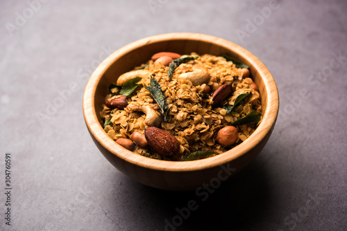 Oats Chivda / Chiwda is a healthy indian recipe with added chilli, peanuts, cashew, almond and curry leaf for flavour. Selective focus