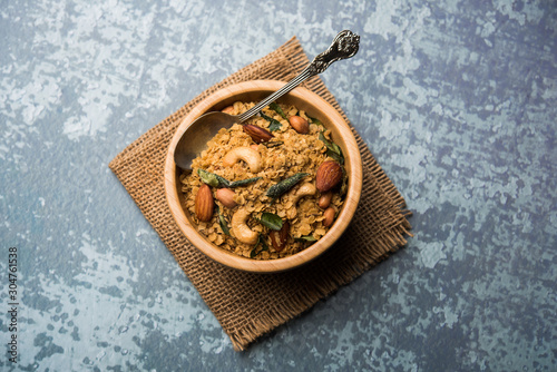 Oats Chivda / Chiwda is a healthy indian recipe with added chilli, peanuts, cashew, almond and curry leaf for flavour. Selective focus photo