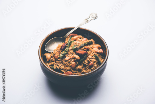 Oats Chivda / Chiwda is a healthy indian recipe with added chilli, peanuts, cashew, almond and curry leaf for flavour. Selective focus photo