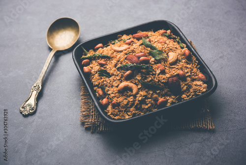 Oats Chivda / Chiwda is a healthy indian recipe with added chilli, peanuts, cashew, almond and curry leaf for flavour. Selective focus photo