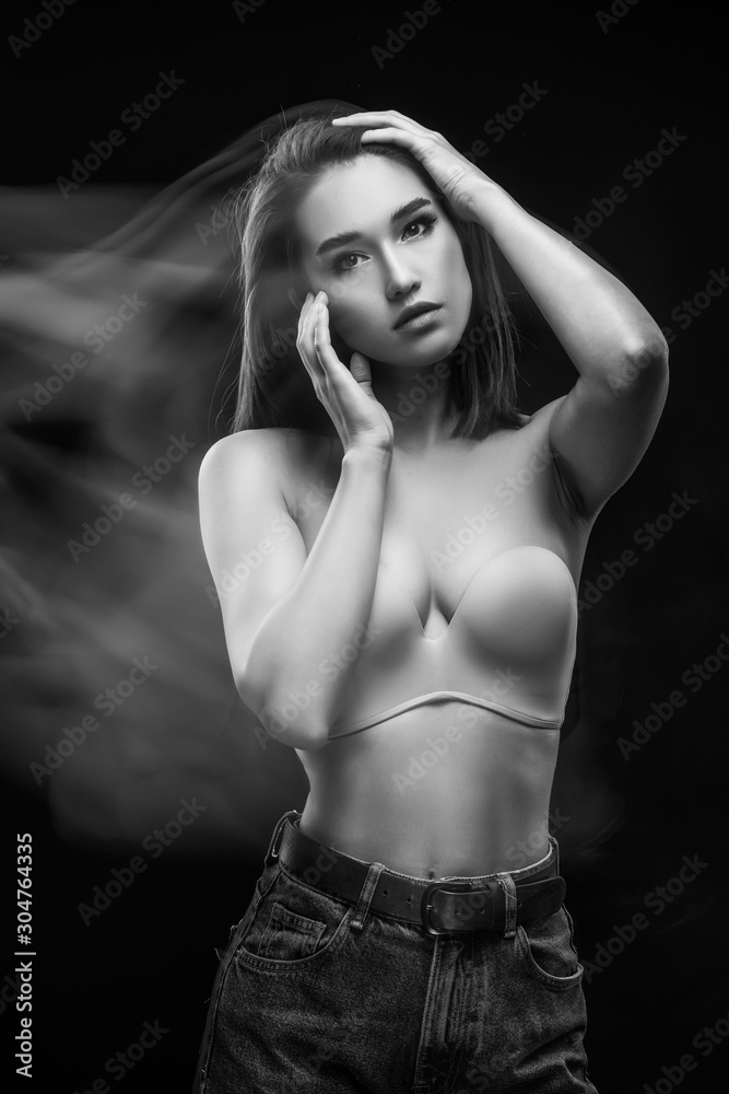 Beautiful mixed race Asian girl with big breasts, wearing a bra and jeans, moves and dances in long and multiple exposure. Advertising, commercial and artistic monochrome black and white design. Beautiful mixed race Asian girl with big breasts, wearing a bra and jeans, moves and dances in long and multiple exposure. Advertising, commercial and artistic monochrome black and white design.