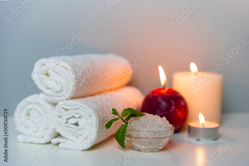 Candles, stack of white towels, sea salt. SPA & Natural health concept photo, horizontal orientation.