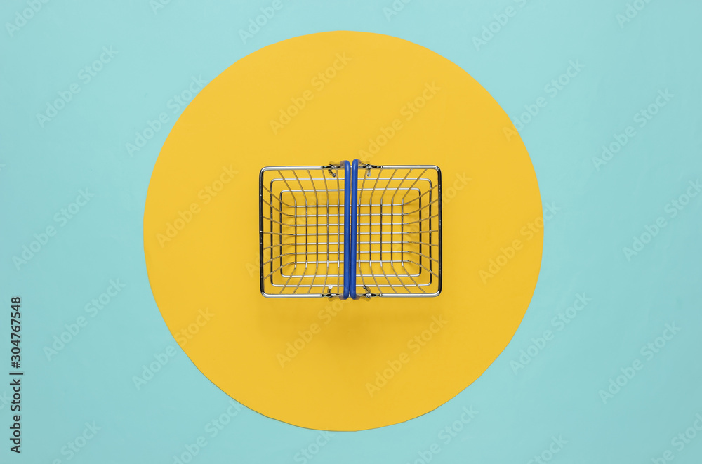 Mini shopping basket on blue background with yellow circle. Top view Mini shopping basket on blue background with yellow circle. Top view