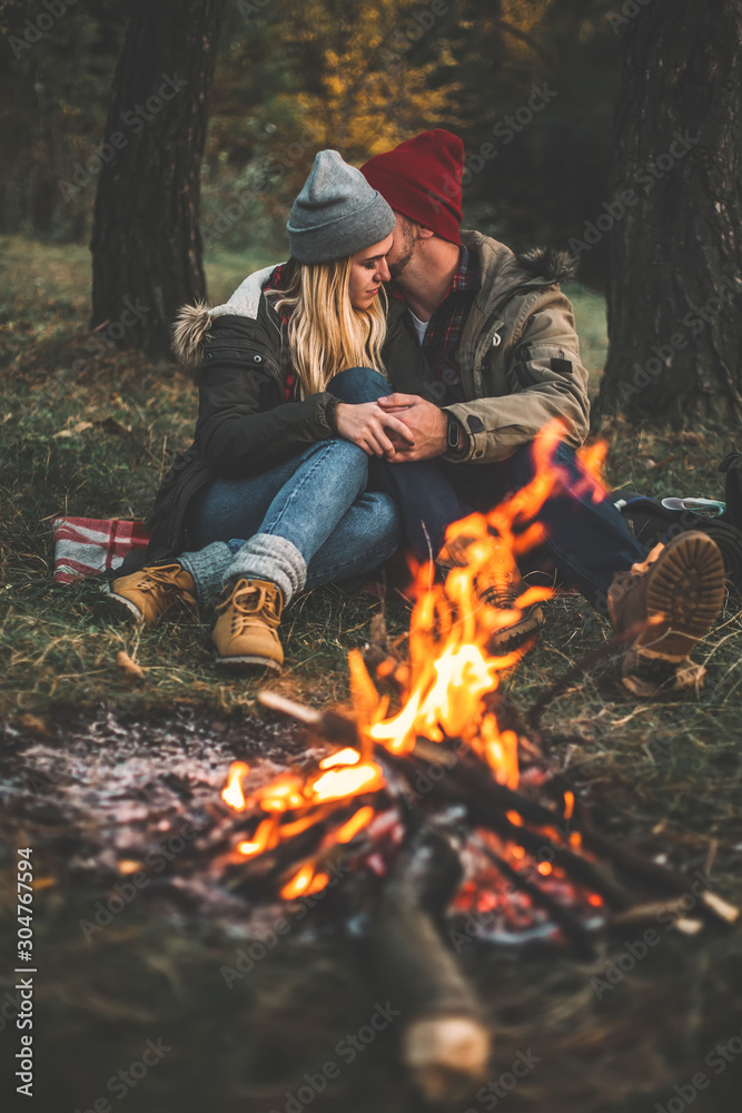 Traveler couple camping in the forest and relaxing near campfire after a hard day. Concept of trekking, adventure and seasonal vacation. Traveler couple camping in the forest and relaxing near campfire after a hard day. Concept of trekking, adventure and seasonal vacation.
