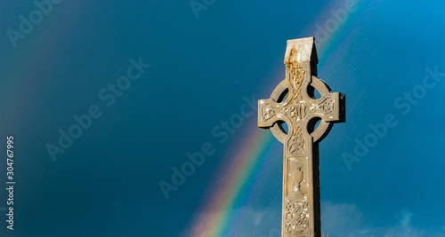 Foto Rainbow over ancient Irish cemetery Celtic cross