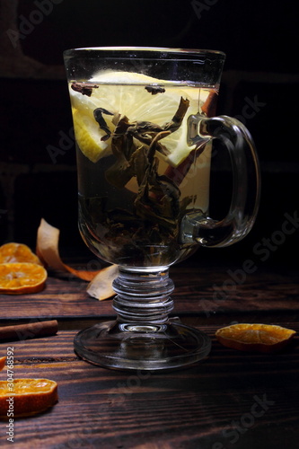 Tea in a glass with lemon slices, cinnamon and spices