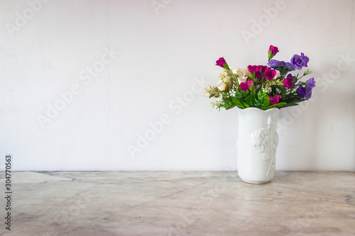 Isolate  art white basket and colorful flowers place on grey marble surface table and white and clear Concrete wall. Abstract background  and nobody template with relaxation feeiling clean and clear.
