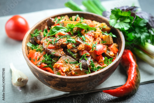 Canvas-taulu Vegetable saute or caponata, or pisto with eggplant, peppers, tomatoes and herbs in rustic bowl on a dark background