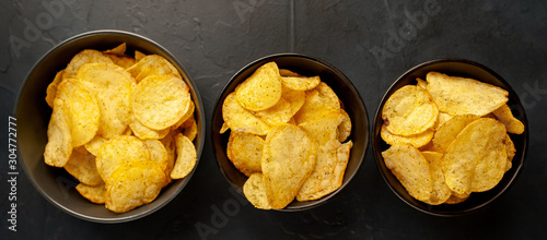 potato chips in three bowls, beer snacks on a stone background