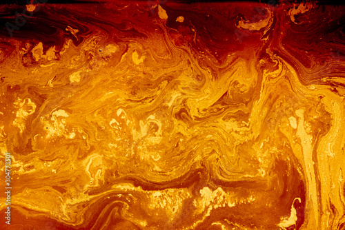 Abstract golden orange background. Flashes in the sun, liquid fire. Flowing lava colors paint photo
