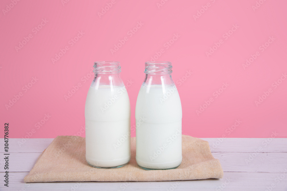 Milk bottle on table with pink background. Milk bottle on table with pink background.