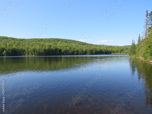 Fototapeta Naklejka Na Ścianę i Meble -  Viewpoint over Lake. La Mauricie National Park, Quebec Canada.Look out point with blue sky and tranquil waters landscape