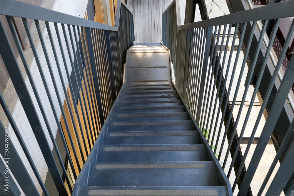 Fototapeta Metalowe schody do schodzenia idą prosto na zewnątrz budynków.