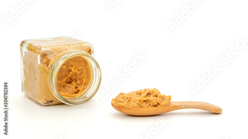 Peanut butter in a spoon and bottle on a white background.