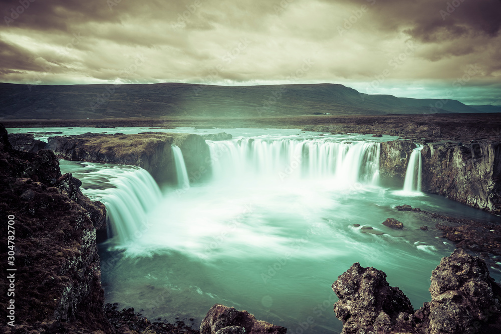 Fototapeta premium Godafoss waterfall, foggy from waterspray on a cloudy morning, Iceland