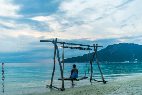 Teluk Keke Beach, Besur, Perhentian Islands, Malaysia; 17-May-2019; a lady enjoying a swing by the sea at sunset, Teluk Keke Beach, Besur, Perhentian Islands, Malaysia