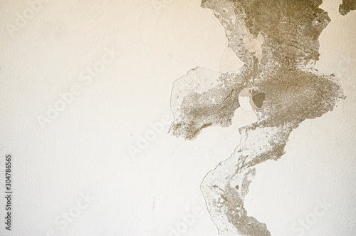 White grey old wall with shabby damaged plaster Cement and brick background of an vintage dirty exfoliating plaster Textured background peeling of colour wallpaper cement