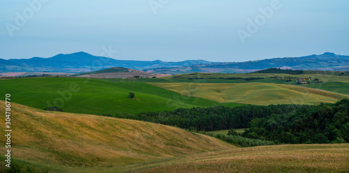 View of a sunny day in the Italian rural landscape. Unique Tuscany landscape in summer time. Wave hills, colorful fields, cypresses trees and sky. © eskstock
