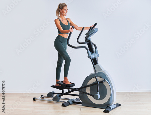 Woman exercising at the gym on crosstrainer photo