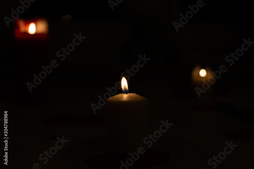 Candle on black background. Candle lighting in the room. © Tudorean