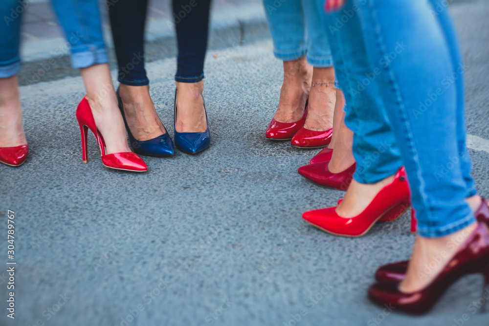 Row line of a legs on high heels in jeans pants during bachelorette party or a birthday, a group of bridesmaids having fun