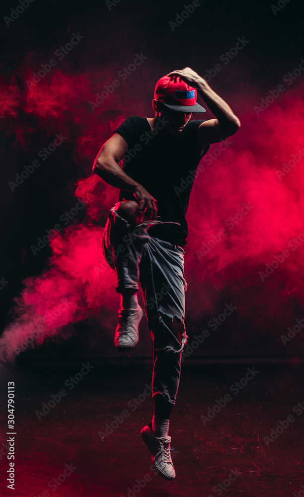 portrait of vigorous dancer male dancing street dance, jump in the air isolated over smoky background portrait of vigorous dancer male dancing street dance, jump in the air isolated over smoky background