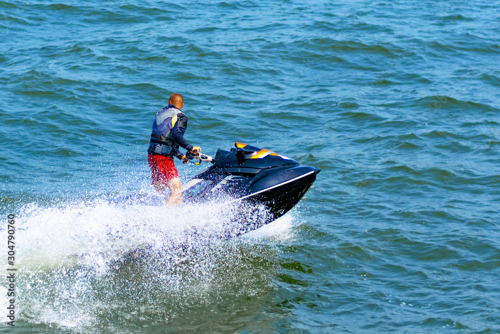 Man on a water bike on the nice blue sea. One man riding water bikes during the holidays.